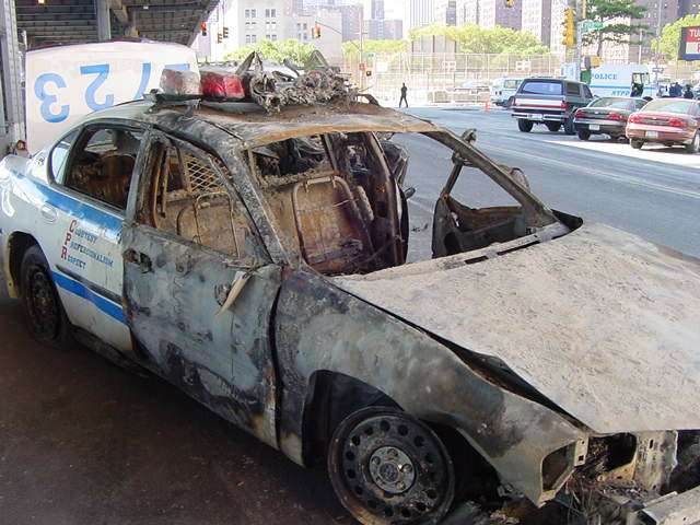 Figure 47. (9/13/01) NYPD Car 2723 on FDR Drive showing abrupt boundary between damaged front section with oxidized steel and pristine rear door, demonstrating selective impedance heating